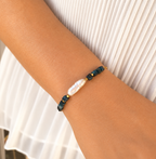 Pulsera AILA con perla barroca y ojo de tigre azul lago sobre muñeca