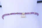  Detalle de pulsera elástica de circonita morada con elefante dorado
