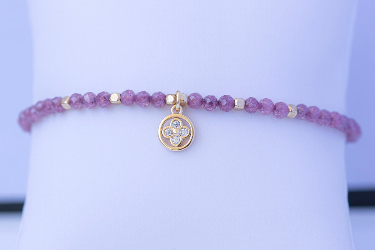  Detalle de charm de flor y cuentas de circonita morada facetada
