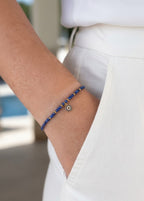 Pulsera Lapislazuli en dorado con amuleto Ojo Turco puesta en la muñeca