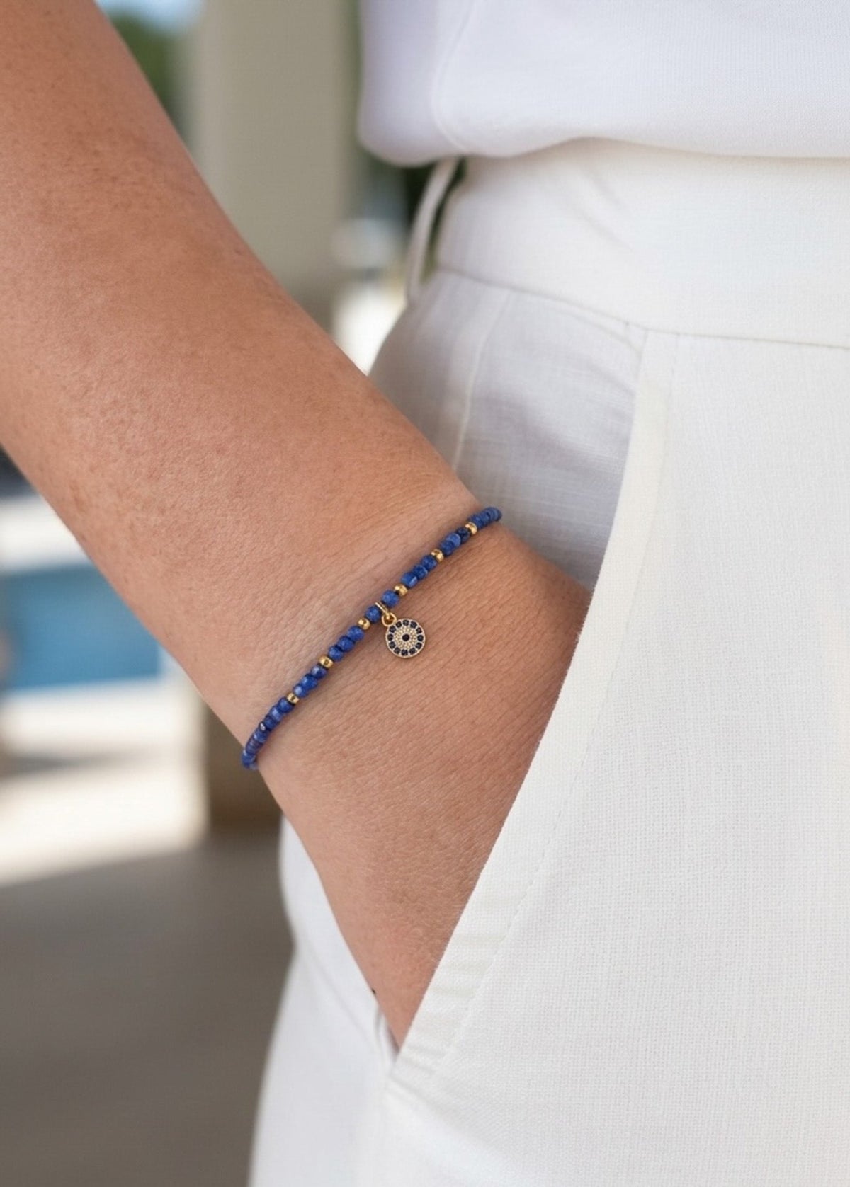 Pulsera Lapislazuli en dorado con amuleto Ojo Turco puesta en la muñeca