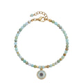 Pulsera YANA de ópalo peruano natural con dije floral y acero inoxidable dorado.

