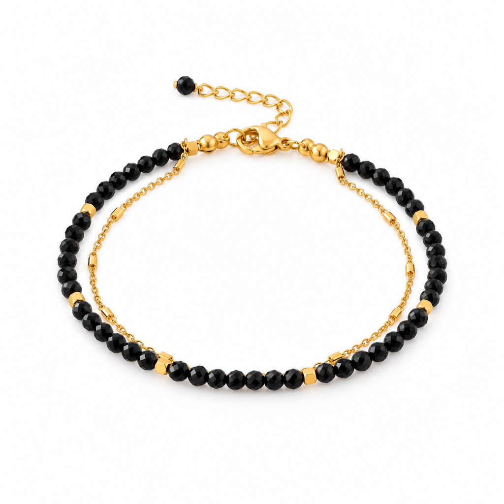 Pulsera MAHIRI de espinela negra facetada con detalles dorados y cadena de acero inoxidable