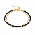 Pulsera MAHIRI de espinela negra facetada con detalles dorados y cadena de acero inoxidable