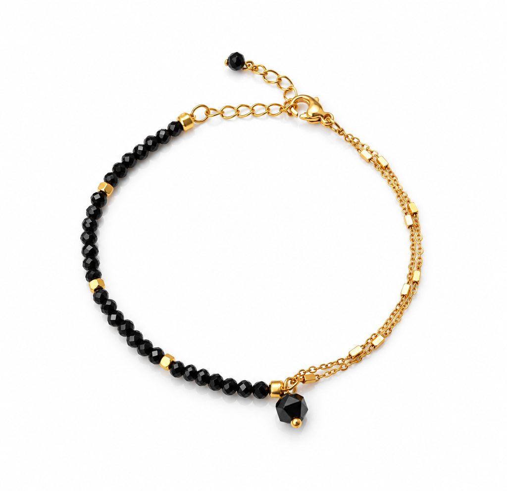 Pulsera RHEA de espinela negra facetada y acero inoxidable dorado
