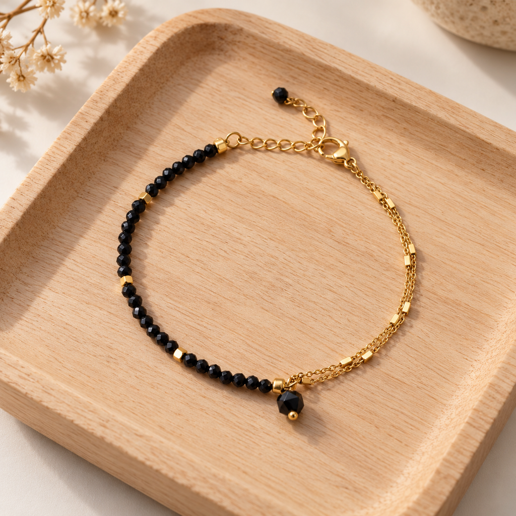 Detalle de pulsera RHEA de espinela negra sobre bandeja de madera