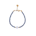 Pulsera de hematita natural con perla de agua dulce y detalles dorados.
