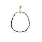 Pulsera de hematita natural con perla de agua dulce y detalles dorados.
